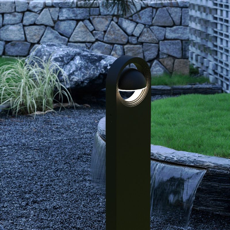 Ningbo Hanyuan smart Tuya floor lamp explore black, illuminating a garden area with stones and greenery, showcasing its modern outdoor design.