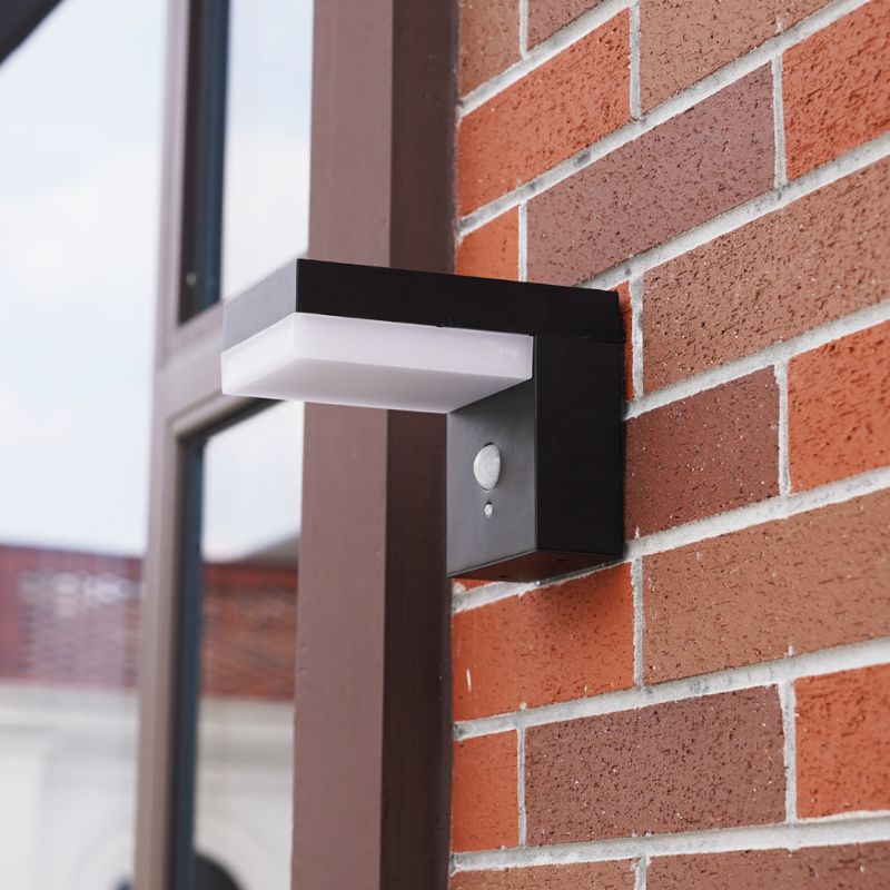 Ningbo Hanyuan solar-powered wall lamp Venus in black, mounted on a brick wall, providing eco-friendly outdoor lighting with a sleek, modern design.