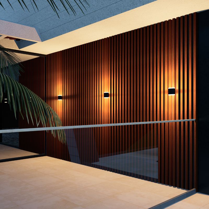A sleek black indoor wall lamp illuminating a modern wooden wall with vertical slats, designed to enhance the ambiance with soft, focused lighting.